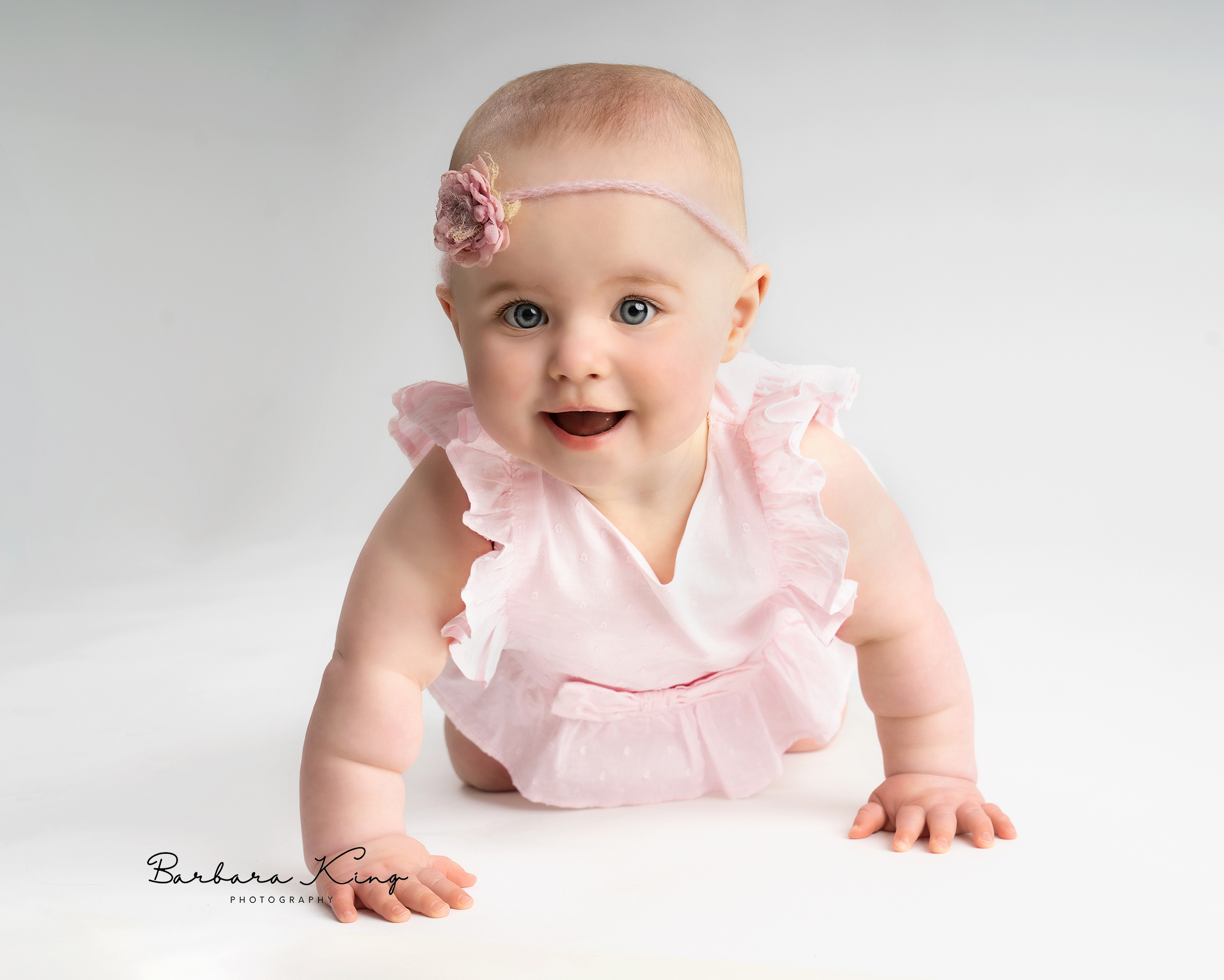 baby girl with blue eyes crawling and smiling